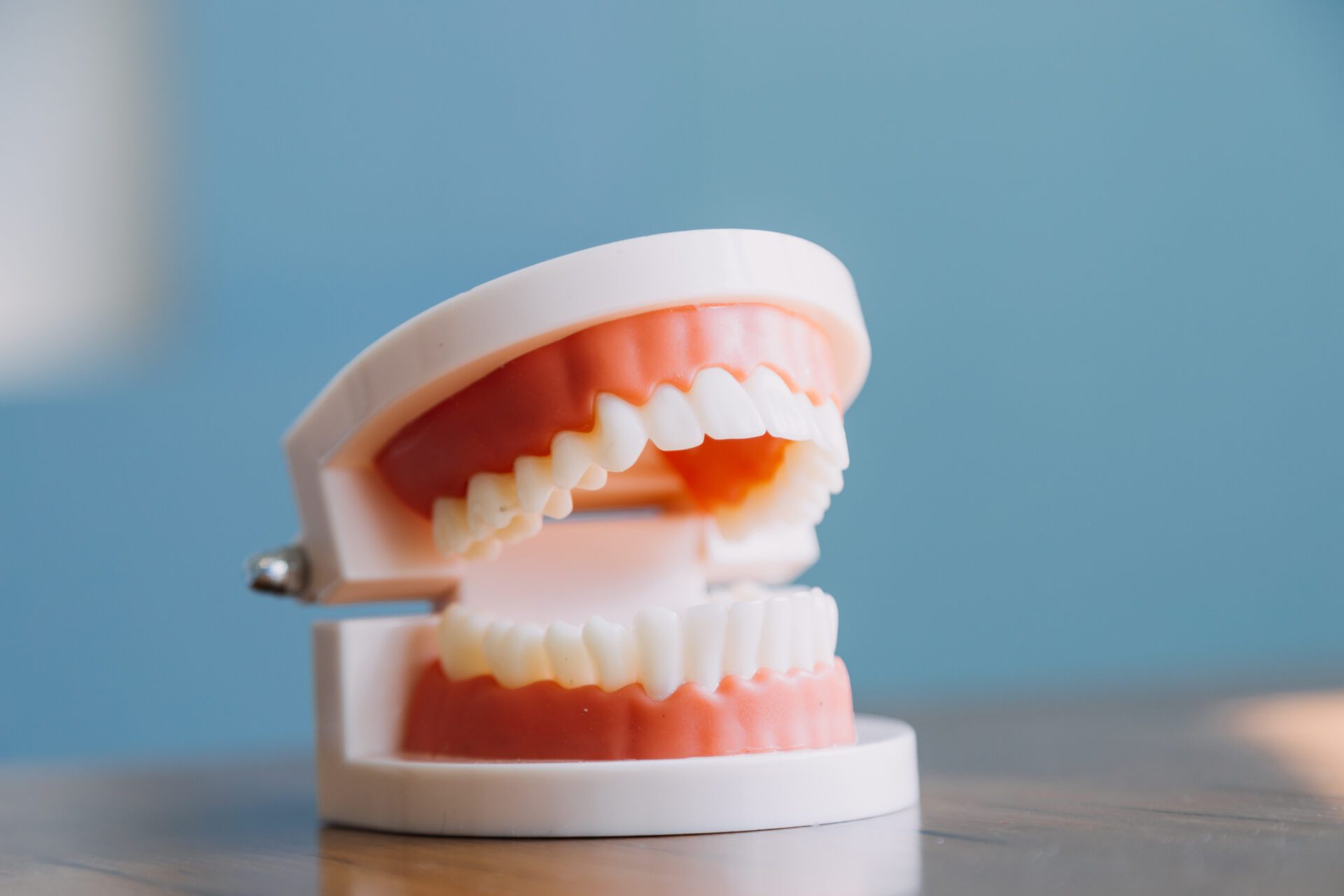 Stomatology concept, partial portrait of girl with strong white Stomatology concept, partial portrait of girl with strong white teeth looking at camera and smiling, fingers near face. Closeup of young woman at dentist's, studio, indoors